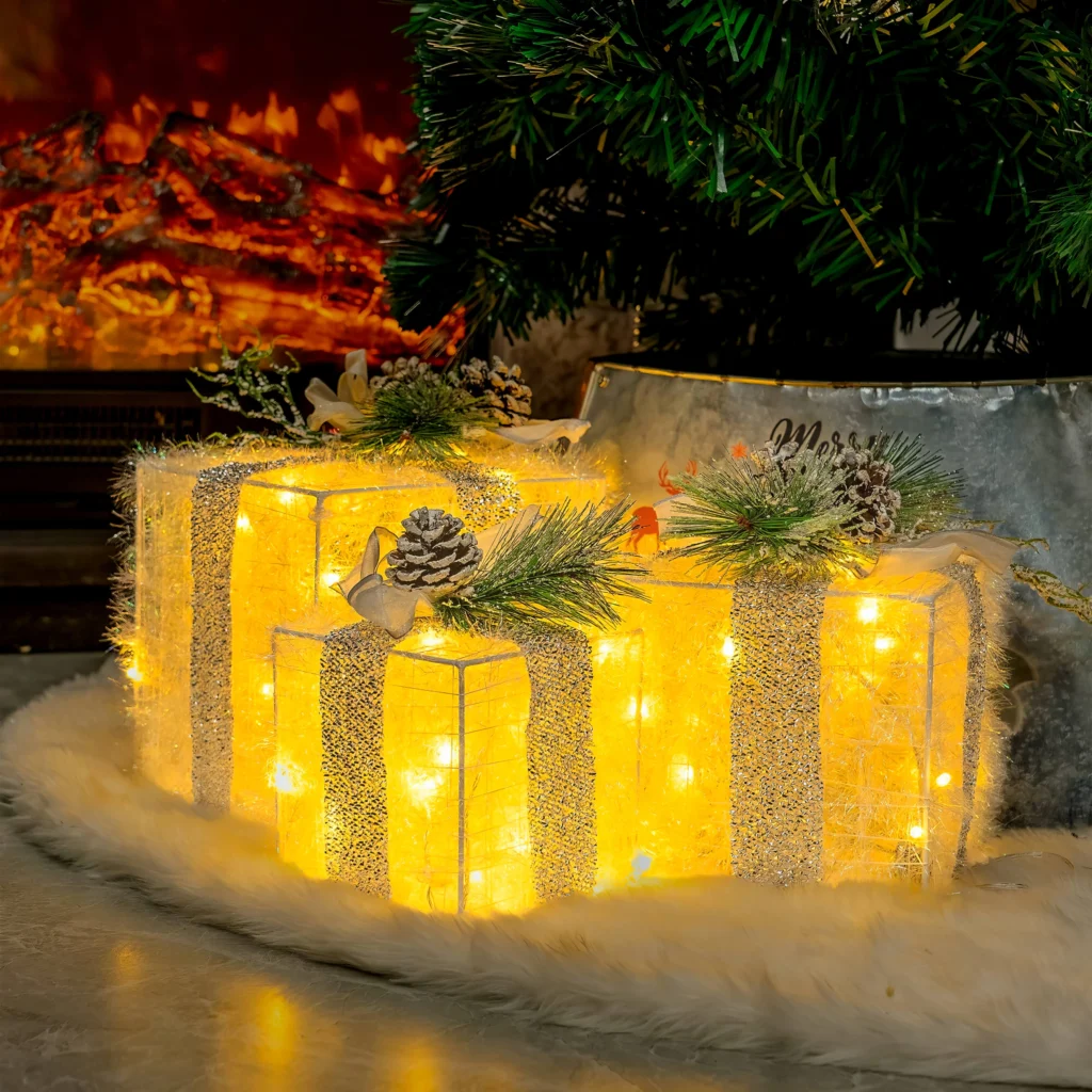 Golden Gleam Gift Box Set with three illuminated gold boxes, bows, and pinecone accents